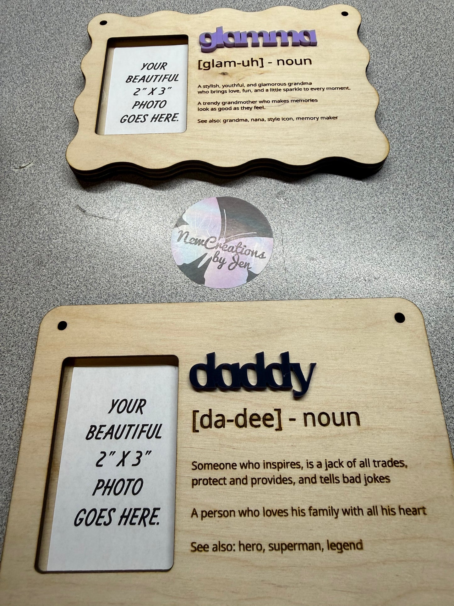 Two wooden photo frames with engraved text on a gray surface