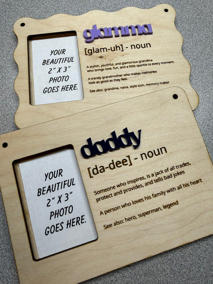 Two wooden hanging photo frames with family nicknames & definitions text on a dark surface