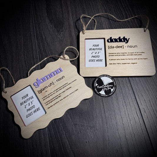 Two wooden hanging photo frames with family nicknames & definitions text on a dark surface