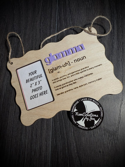 Wooden photo frame with 'glamour' definition and photo placeholder on a dark surface