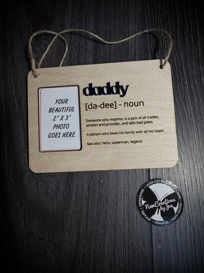 Wooden plaque with text and photo placeholder for 'daddy' on a dark surface.