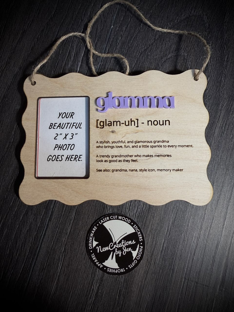Wooden photo frame with 'glammu' definition and placeholder for photo on a dark wooden background.