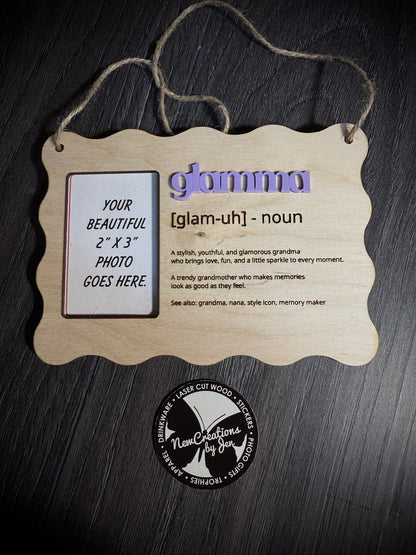 Wooden photo frame with 'glammu' definition and placeholder for photo on a dark wooden background.