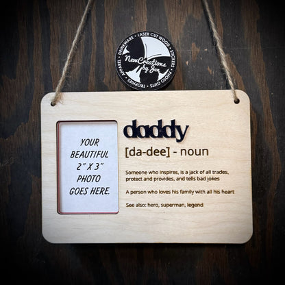 Wooden plaque with 'daddy' definition and photo placeholder on a dark wooden background