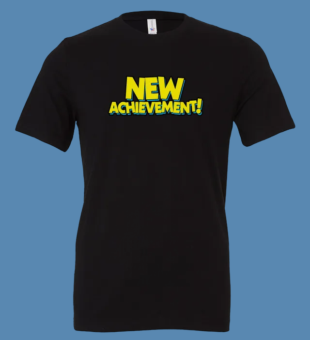 Black t-shirt with 'NEW ACHIEVEMENT!' text in yellow on a white background