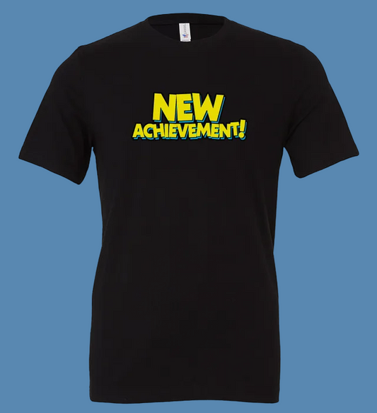 Black t-shirt with 'NEW ACHIEVEMENT!' text in yellow on a white background