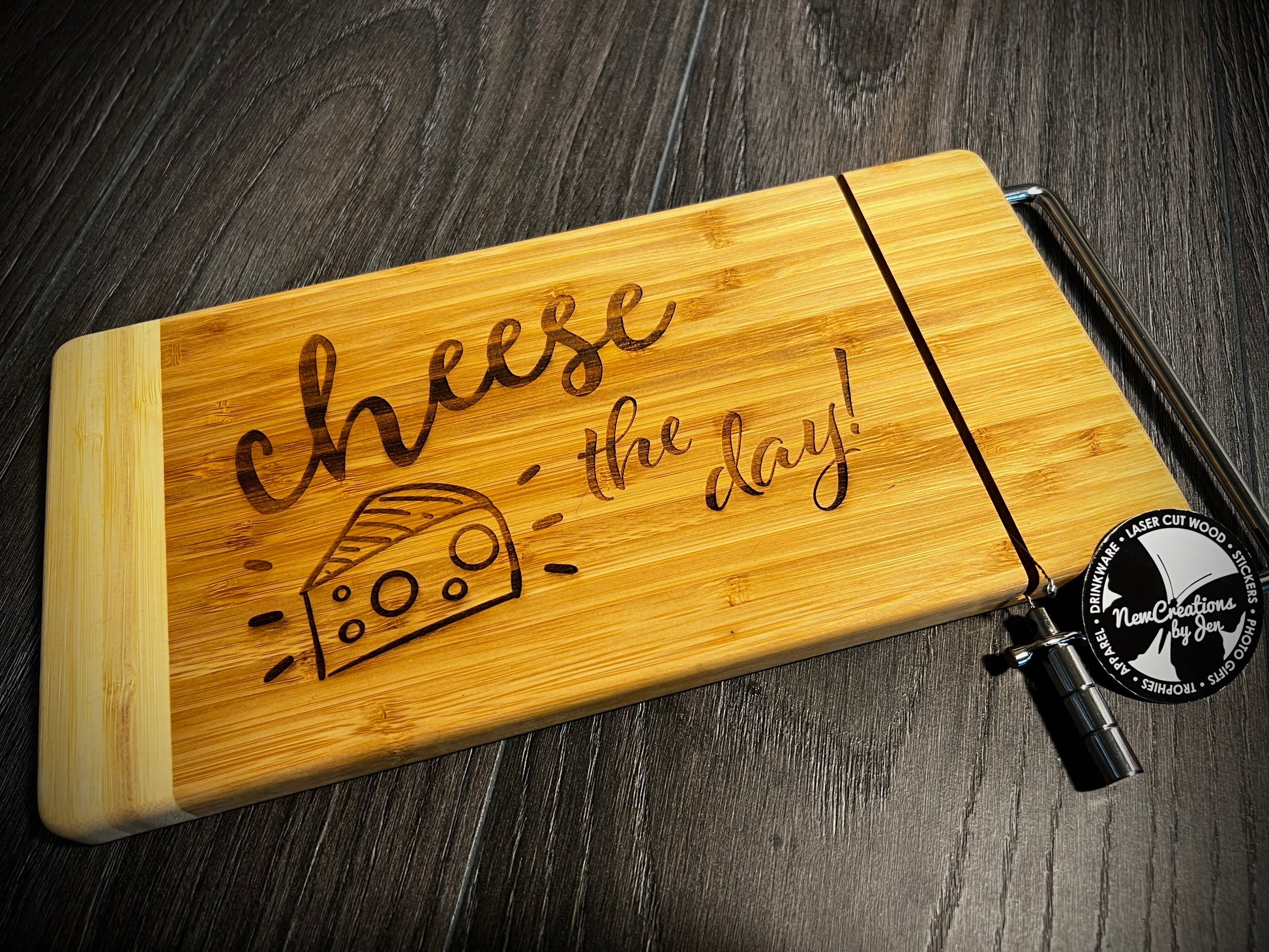 Wooden cheese board with 'Cheese the Day!' engraving on a dark wooden surface.