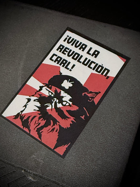 Sticker with a cat illustration and text on a dark surface